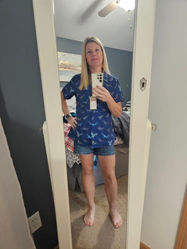 Reviewer in a mirror selfie wearing the blue patterned Avatar "Soaring Banshees" short sleeve shirt.