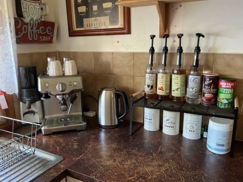 Customer's home coffee station with Irish Cream Coffee Syrup on a rack with other syrups and an espresso machine.