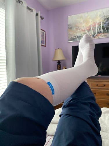 Reviewer resting with feet up, showing the fit of the white Performance Eucalyptus Compression Socks.
