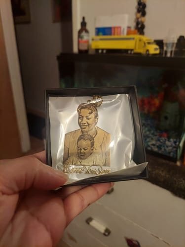 Customer holds open a gift box showing the Custom Photo Engraved Pendant Necklace with an image of a woman and a baby.