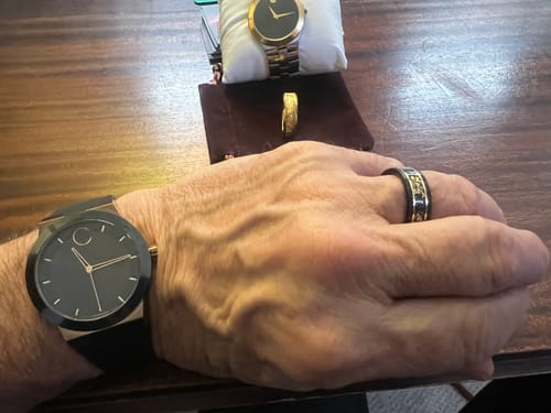 Reviewer wearing the black Titanfall ring with gold flakes on their hand, with a watch on their wrist.