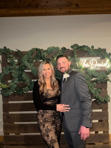 Reviewer posing in the black Obsidian Lace Maxi Dress, styled with a shrug for a formal event.