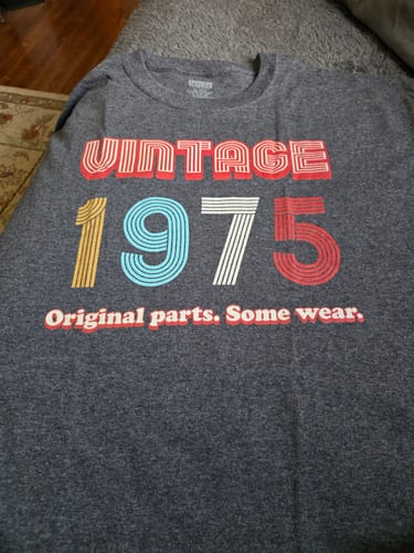 Customer's dark grey 'Vintage 1975' T-shirt laid flat, showing the colorful retro-style graphic.