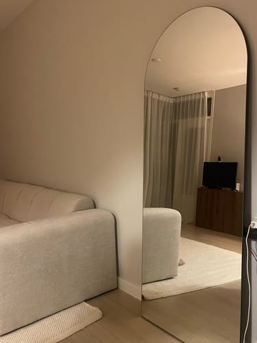 Recensent's witte Chess wollen vloerkleed, deels zichtbaar in de reflectie van een spiegel in de woonkamer.