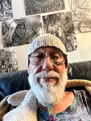 A happy reviewer with a white beard and glasses smiles warmly for the camera.