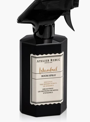 Beoordelaar toont de zwarte, achthoekige fles van de Istanbul Room Spray op een witte achtergrond.