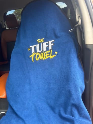 Customer's blue Tuff Towel car seat cover draped over a car's front seat, showing the logo.