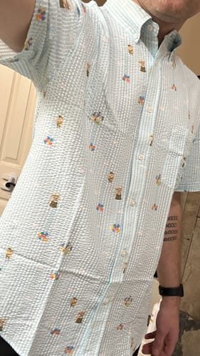 Reviewer showing the fit of the light blue striped "Going Up!" seersucker shirt from the side.