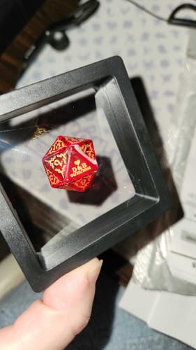 Customer shows their Custom Anniversary D20 Dice in its black display case, with personalized initials visible.