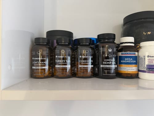 Customer's Australian Grown Mushroom Bundle bottles lined up on a white shelf with other supplements.