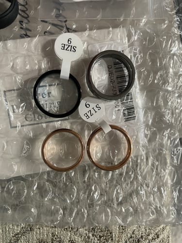 Reviewer's four new rings, including two rose gold Rosmir rings, laid out on bubble wrap.