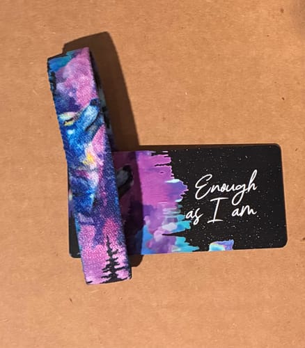 Reviewer's colorful wolf-themed Enough As I Am Bracelet shown with its matching card.