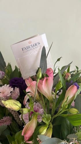 Close-up of a customer's Harmony Flower Arrangement, showing beautiful pink and purple flowers with a card.