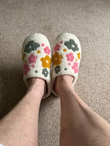 Customer wearing the cozy Livia Flower Slippers, showing the vibrant floral pattern.