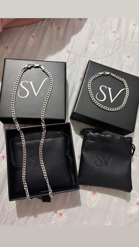 Foto de un cliente de la Pulsera Miami Cuban y un collar a juego, exhibidos sobre su empaque negro con el logo SV.