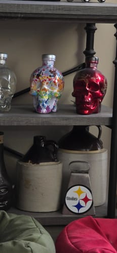 Customer's collection of Crystal Head Vodka bottles on a shelf, including a distinctive red skull.