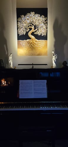 Customer's 3D Tree of Life Wall Art is spotlighted above a piano in a softly lit room.
