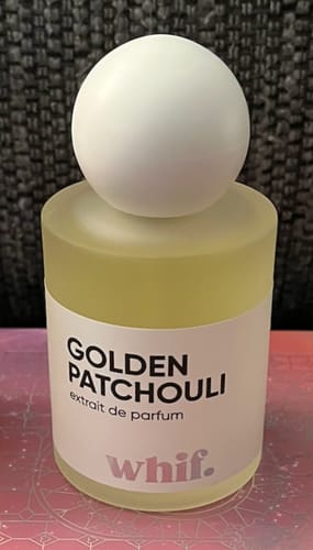 Customer's Golden Patchouli perfume bottle with a frosted base and large spherical cap.