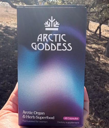 Customer holding the box for Arctic Goddess Reindeer Organ Superfood outdoors.