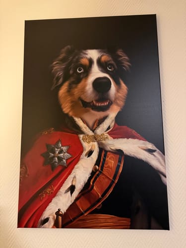 Klant toont het 'De Koning' canvasportret van een hond in een vorstelijk rood gewaad aan de muur.
