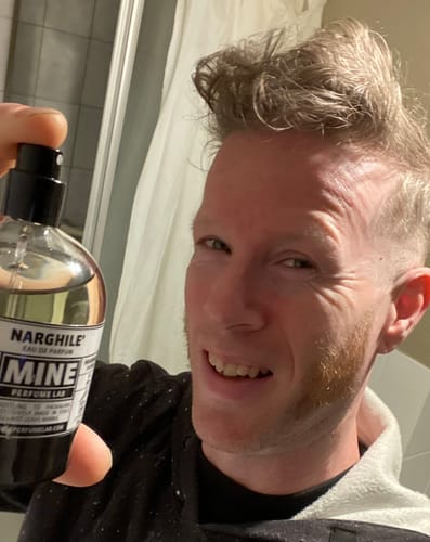 Cliente sorridente mostra il suo flacone di profumo NARGHILE'.