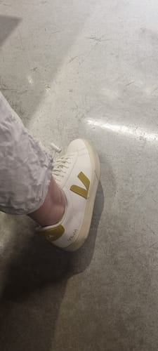 לקוח/ה נועל/ת סניקרס Veja Campo לבנות עם לוגו V בצבע חרדל.