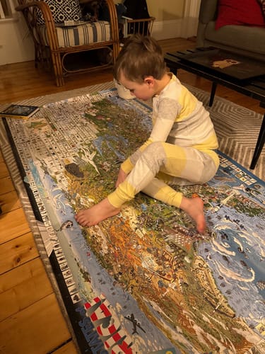 Reviewer's image of a child examining a large, detailed floor map with a Magnifier Glass nearby.