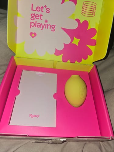 Customer's Lem Clitoral Massager in its open, brightly colored box with the message 'Let's get playing'.