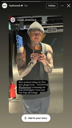 Reviewer's mirror selfie in a gym, with a testimonial praising the energy from hydrava electrolyte salts.