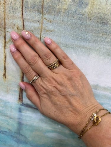 Customer's hand wearing the Layered Gold & Crystal Wrap Ring on the pointer finger, as mentioned in the review.