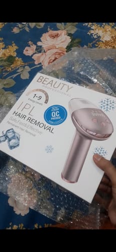 Customer holding the box for the Beaty Professional IPL Laser Hair Removal device over bubble wrap.