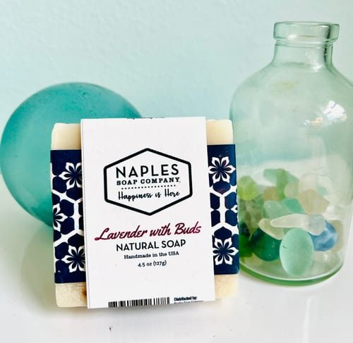 Customer's Lavender with Buds Natural Soap in its packaging, staged next to a decorative glass bottle.