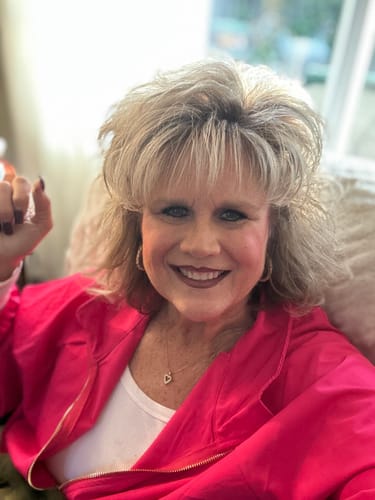 Reviewer in a close-up, wearing the bright pink zip-up jacket from the Two Piece Jogger Set.