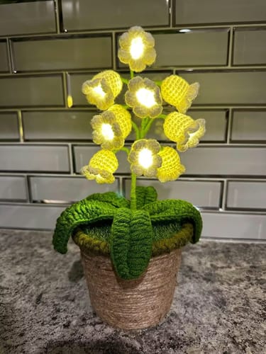 Customer's LitLamp Floral Crochet Lamp glowing on a countertop, showing its warm light and crocheted flowers.