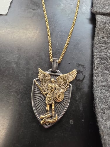 Reviewer's Vintage St. Michael necklace showing the detailed two-tone shield pendant and gold-colored chain.