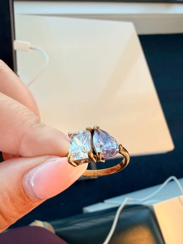 Close-up of a customer holding the elegant Toi Et Moi Birthstone Ring with two different colored stones.