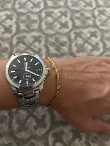 Cliente luciendo la Pulsera Rope Oro en la muñeca, junto a un reloj.