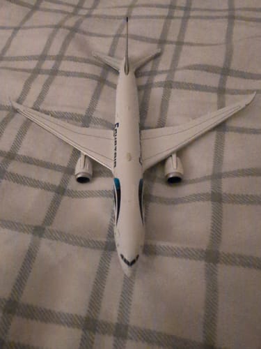 Reviewer's HERPA EGYPTAIR 787-9 model airplane seen from above on a plaid blanket.