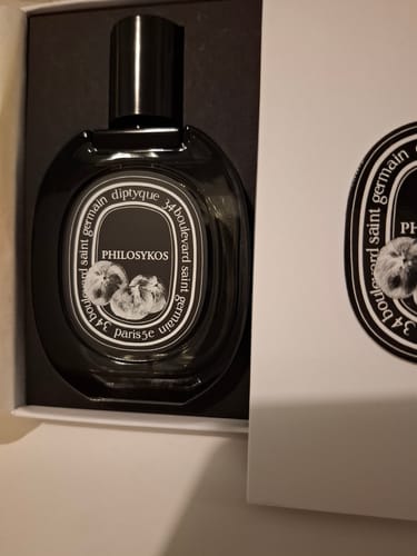 Recensore mostra il flacone di Diptyque Philosykos all'interno della sua confezione aperta.