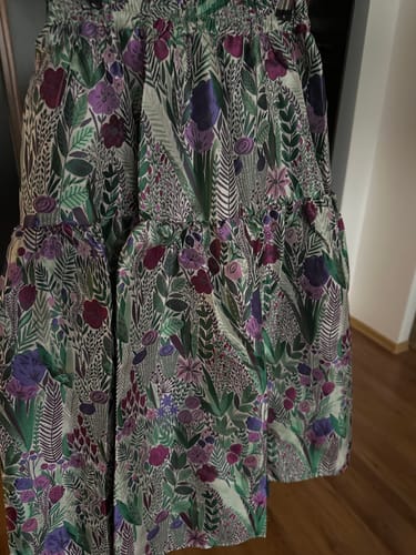 Prim-plan de la un client cu fusta Toria, arătând imprimeul floral bogat și materialul gros.