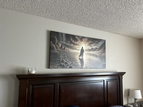 Customer's 'Walking on Water' faith wall art hung on a wall above a dark bed headboard.