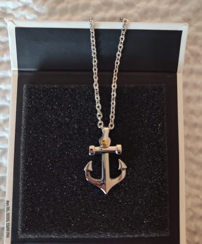 Customer's Gold Screw Anchor Pendant on a silver chain displayed in its open black and white box.