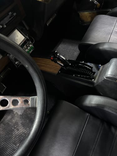 Customer's view from the driver's seat of the installed black Billet Shifter in a car's console.