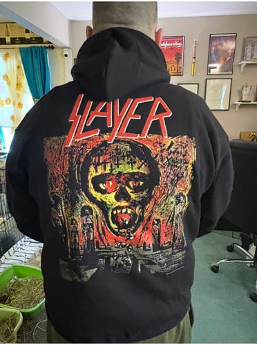 Reviewer showing the back of a black Slayer hoodie with a large, colorful graphic.