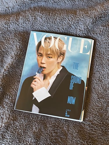 Customer's Vogue magazine with Jimin on the cover, lying on a gray fluffy surface.