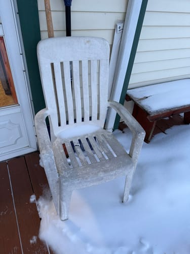 Customer's old, weathered plastic chair sitting outside in the snow for comparison.