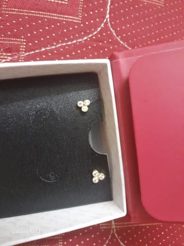 Customer's Golden Three-Stoned Stud Earrings displayed inside the open product box.