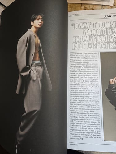 Reviewer showing an open Rolling Stone magazine with a full-page photo of Jungkook in a grey suit.