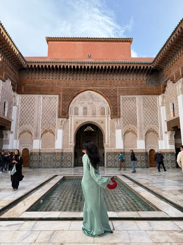 Reviewer in a beautiful Moroccan courtyard, showing the back of the flowing Caftan Maisa.