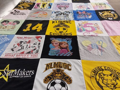 Customer's colorful Premium T Shirt Quilt made from a child's shirts with various fun graphics and logos.